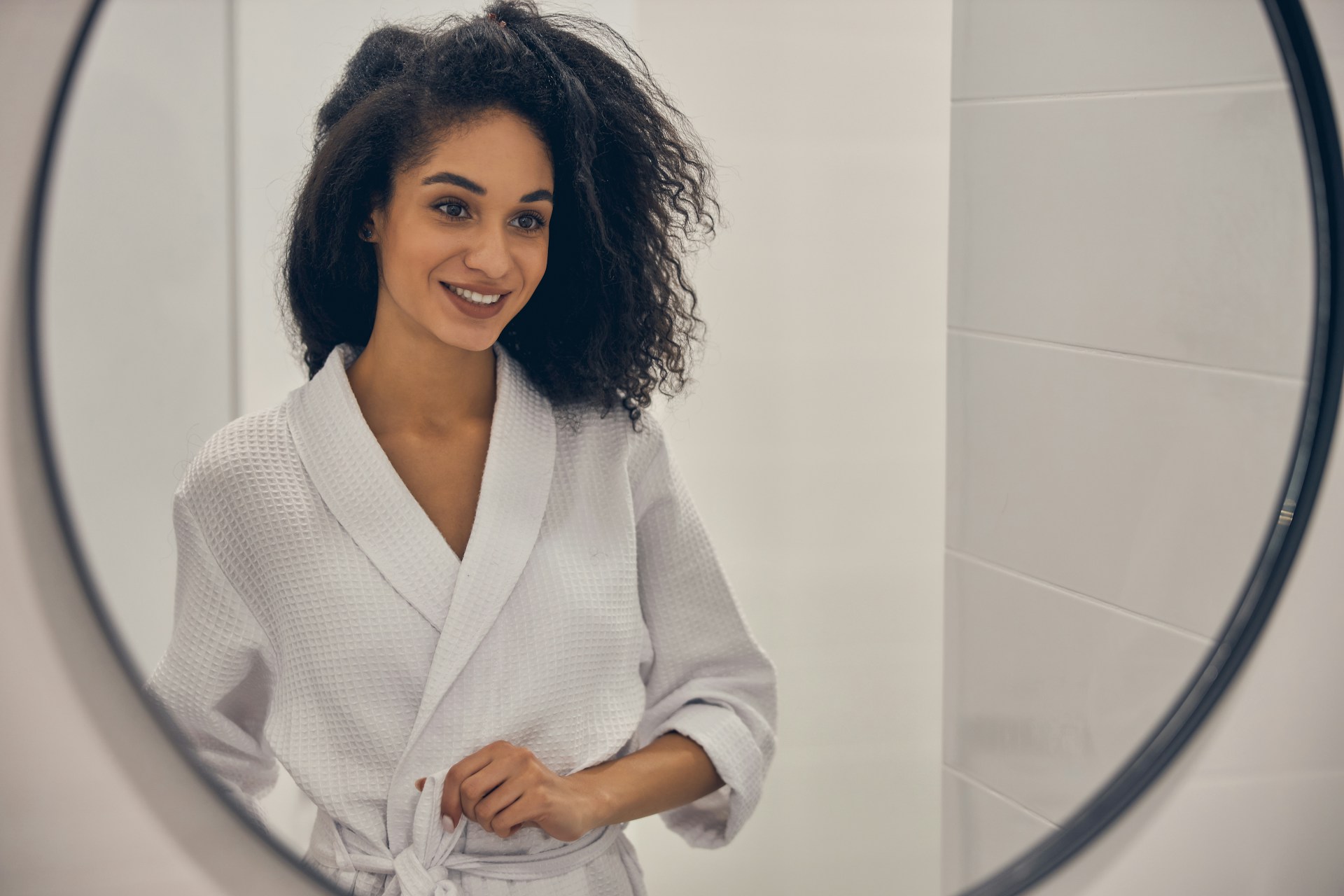woman looking at herself in the mirror after an egg retrieval
