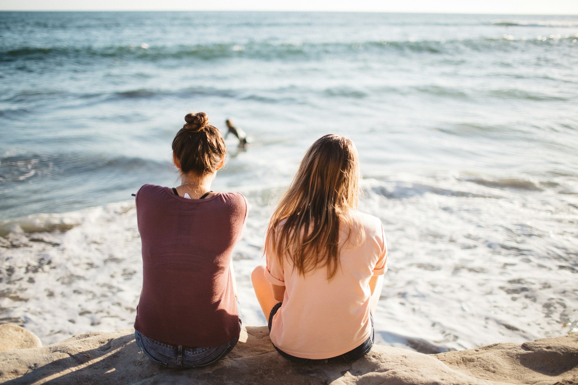 two women sitting on the beach