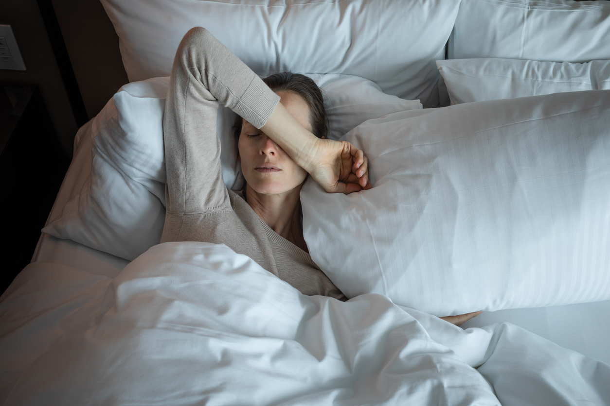 woman managing her anxiety and migraine in bed