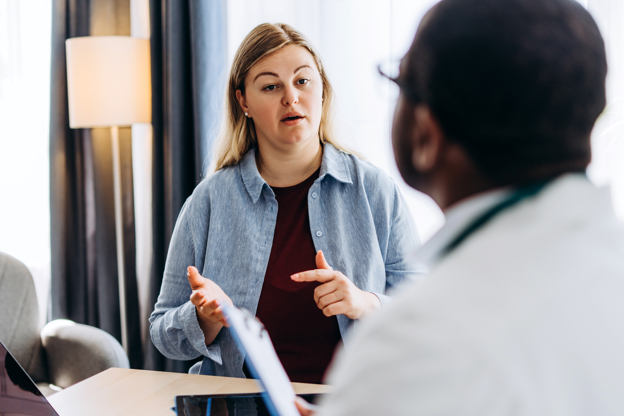 woman discussing migraine symptoms with her doctor