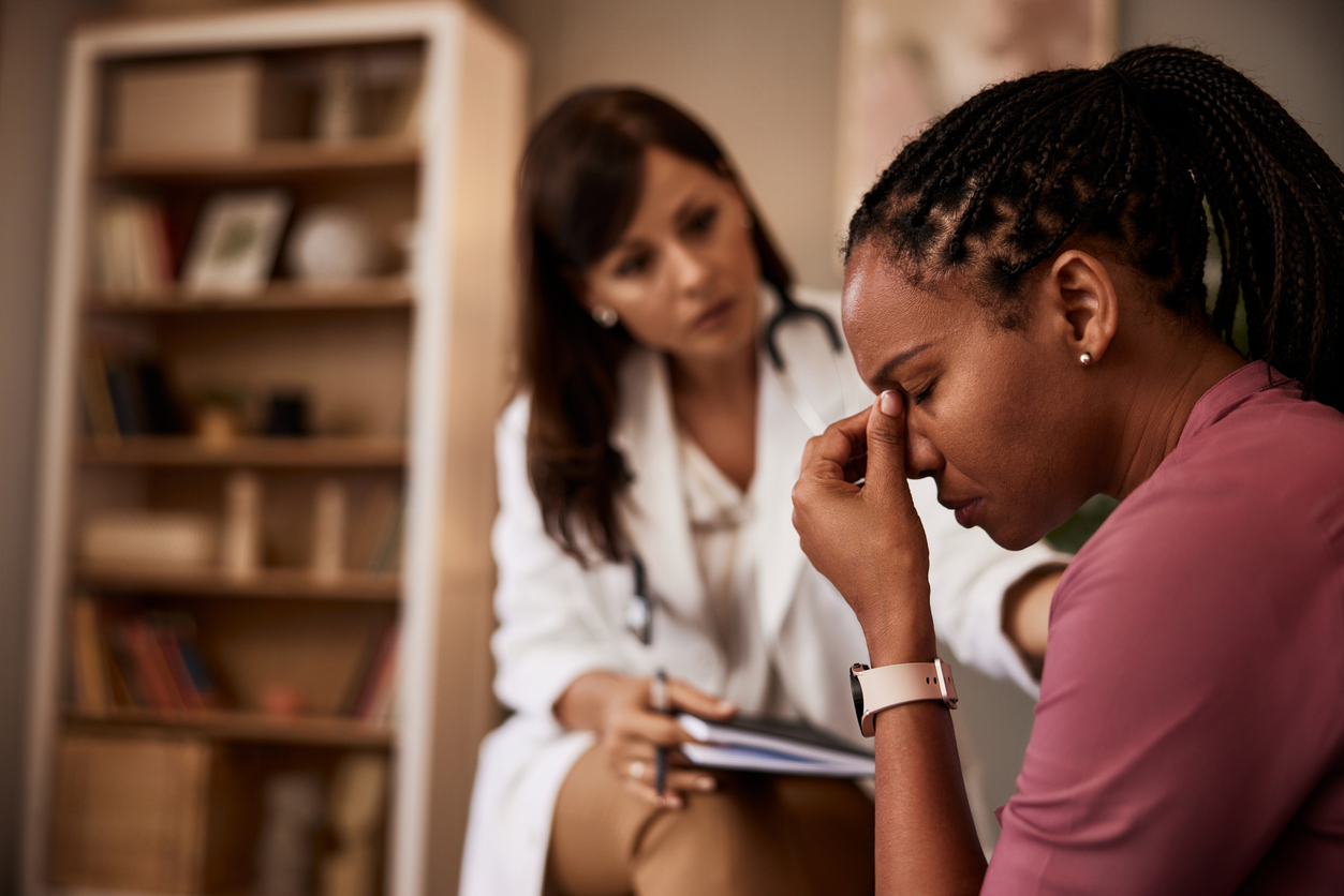 doctor examining a woman with a migraine