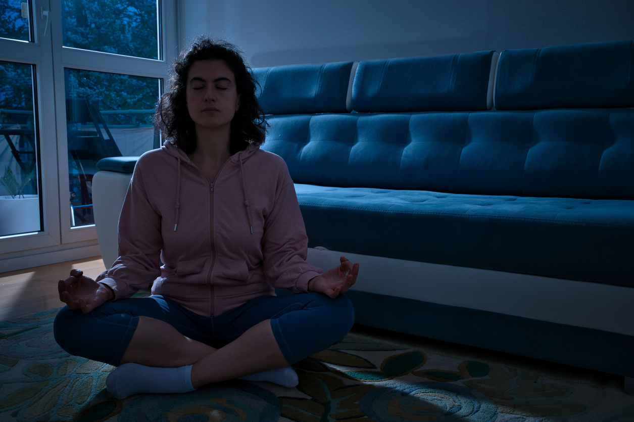woman meditating during a darkness retreat