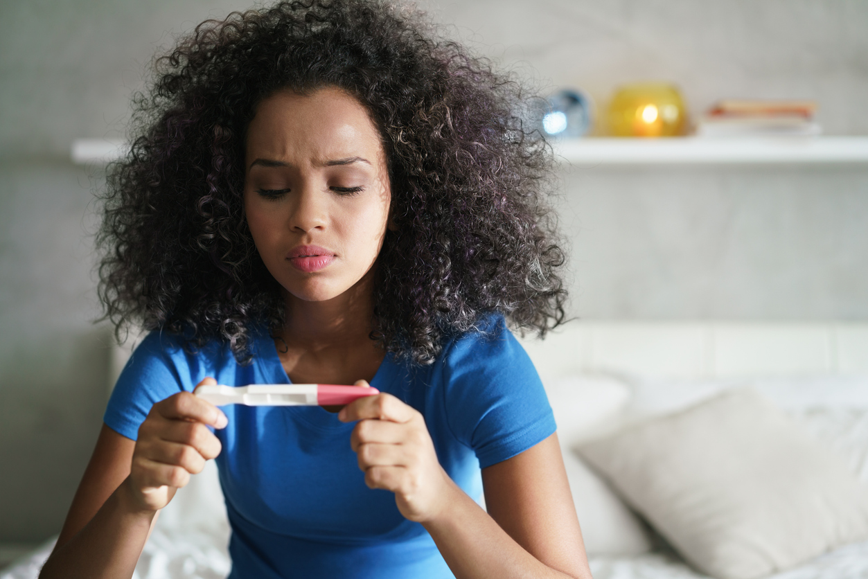 woman looking at a pregnancy test
