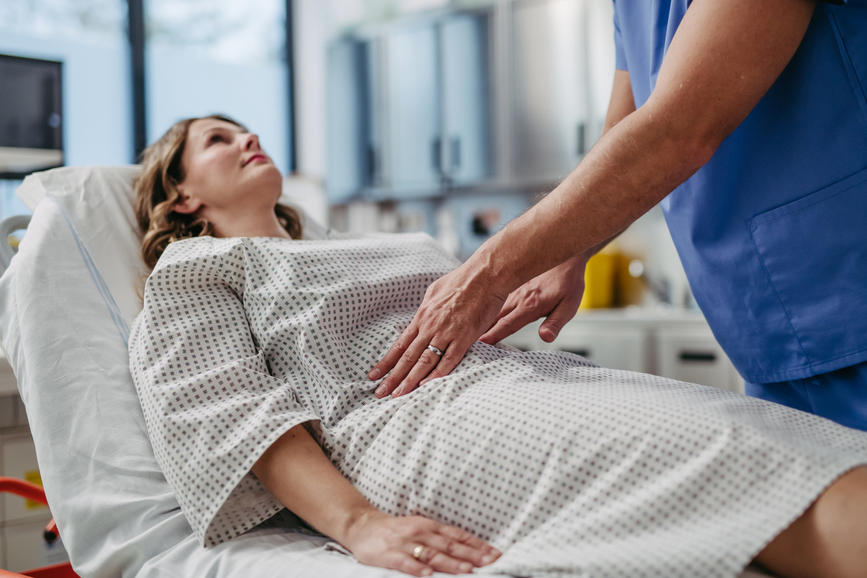 doctor palpating a woman's abdomen
