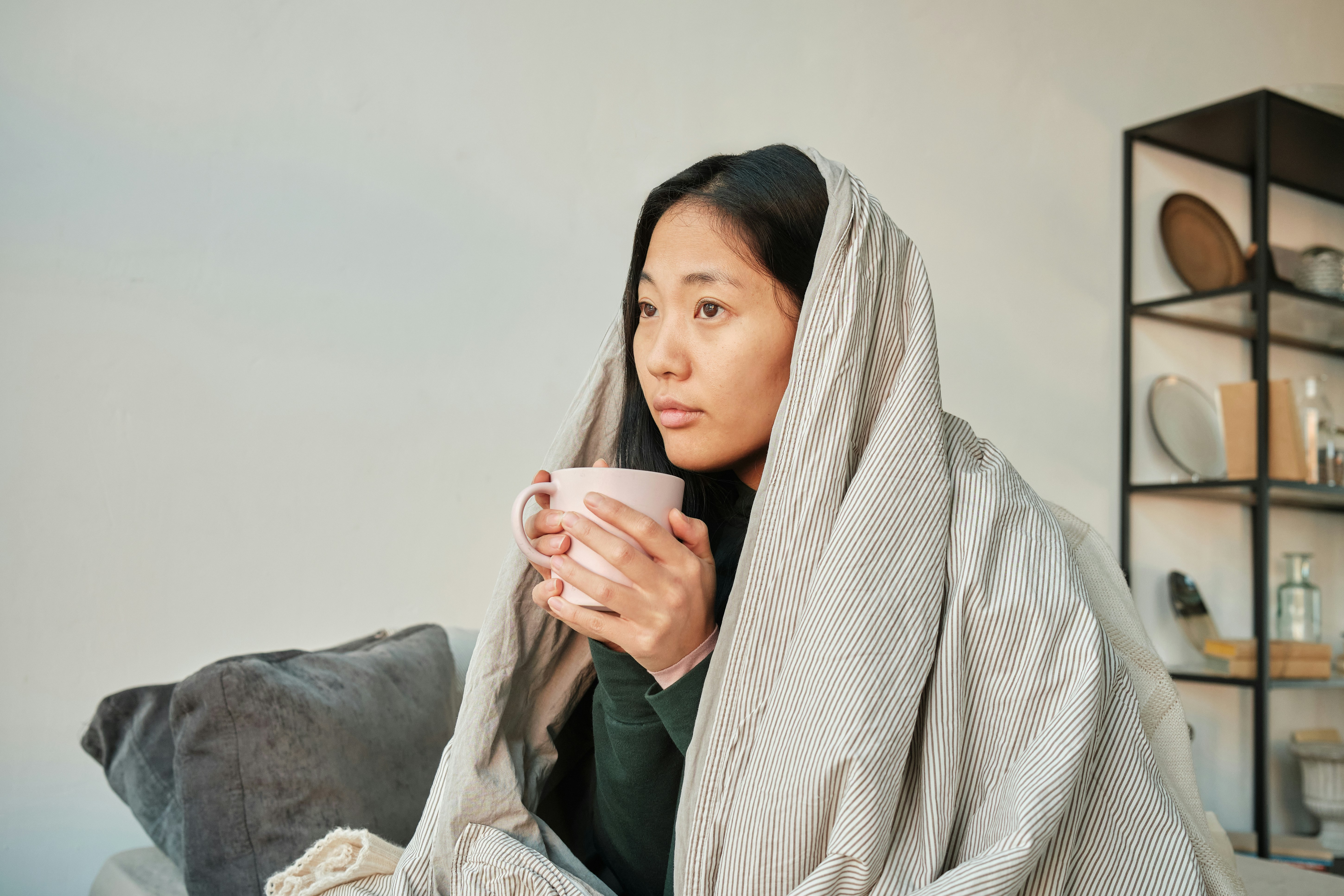 woman drinking coffee to stave off a menstrual migraine