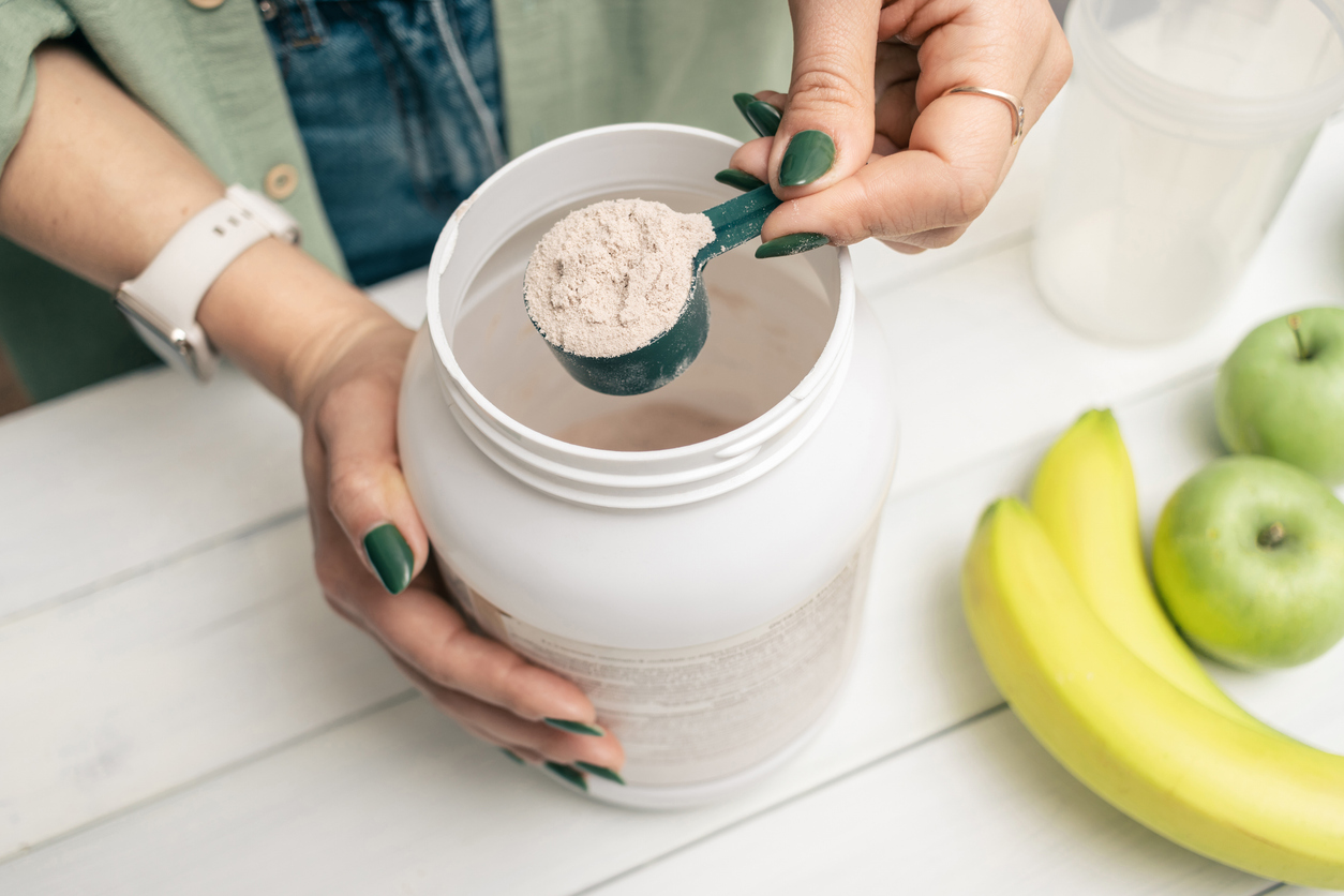 woman scooping protein powder