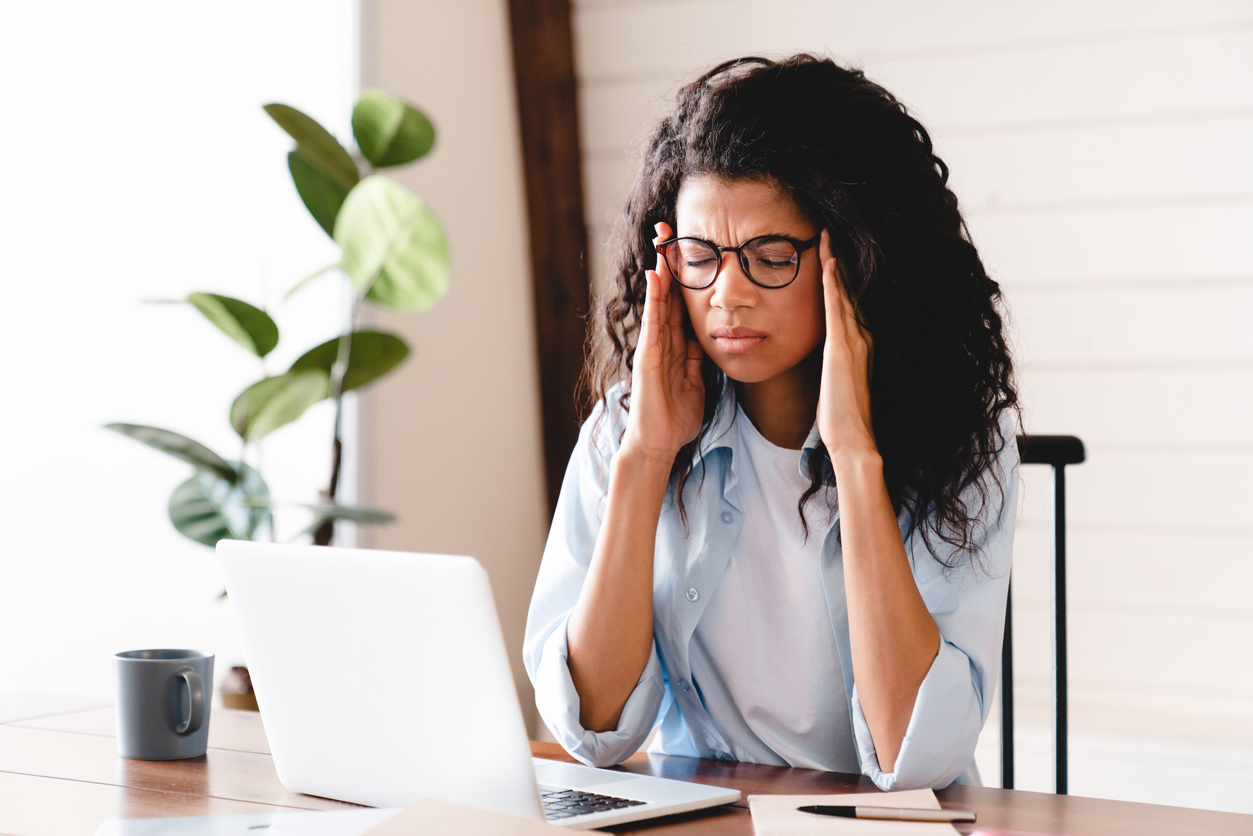 woman feeling a migraine coming on at work