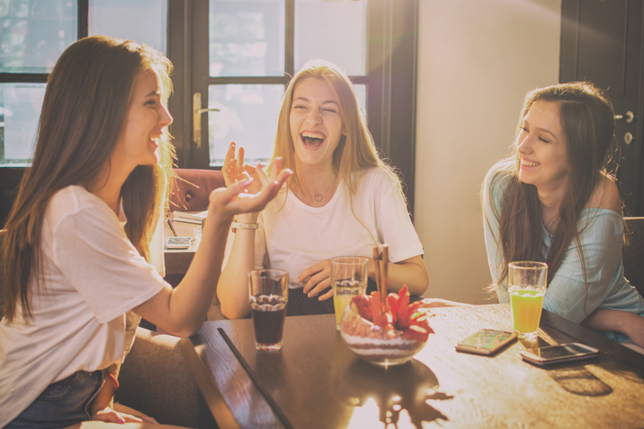 three girlfriends talking over drinks