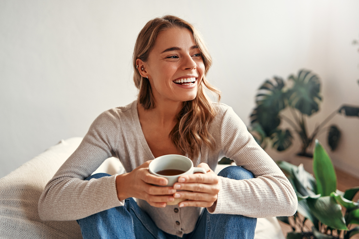 woman smiling, drinking tea