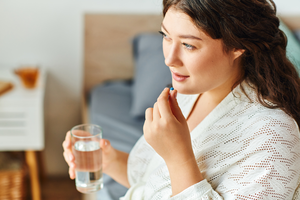 woman taking an iron supplement for heavy periods