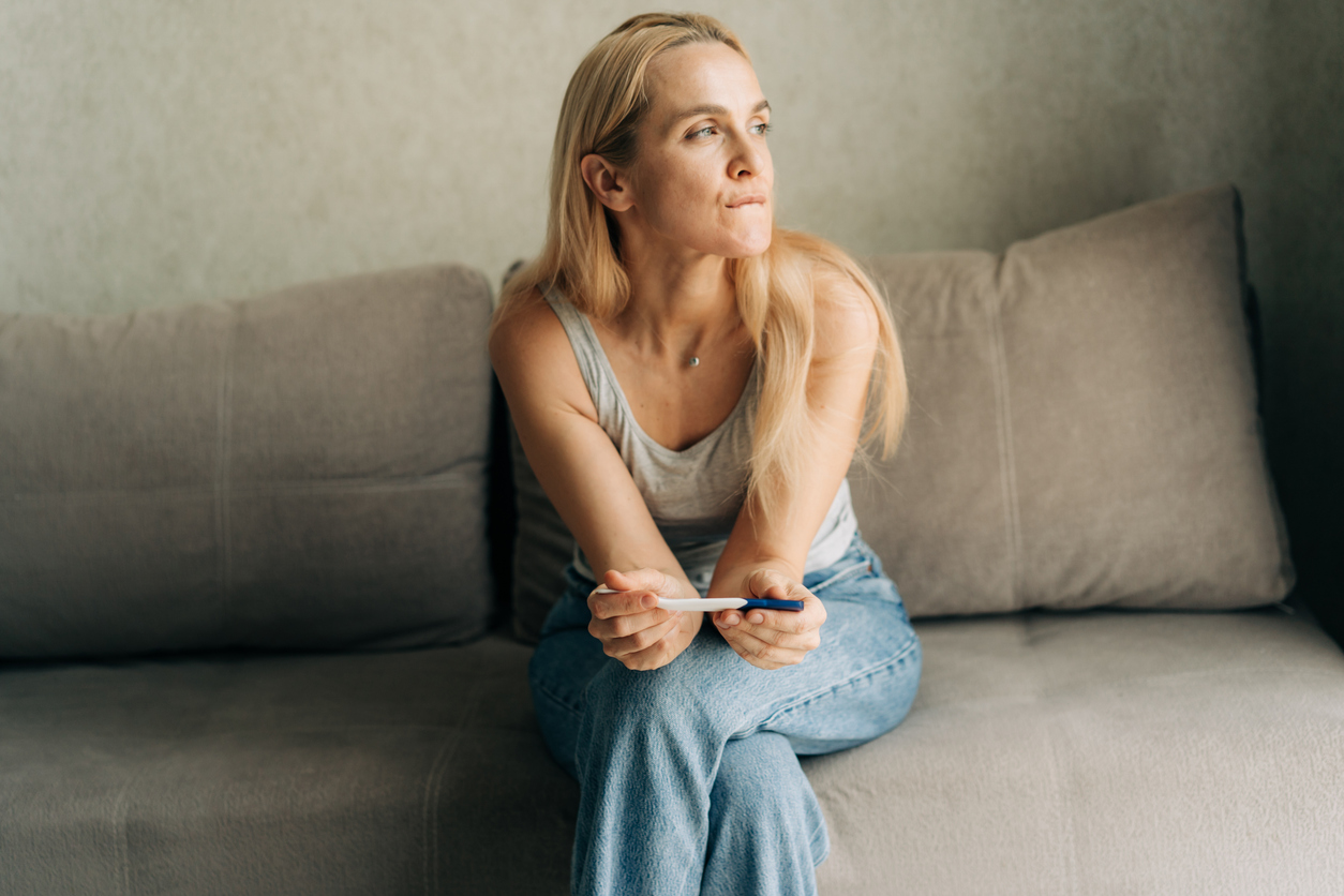 disappointed woman holding a negative pregnancy test