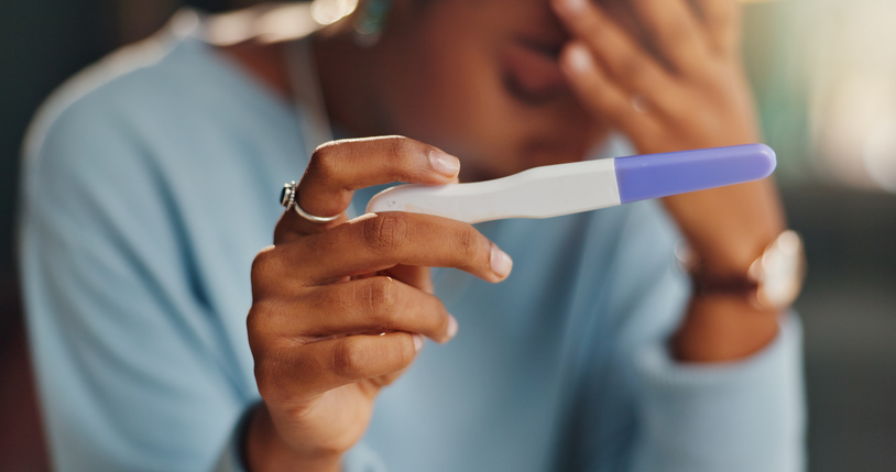 discouraged woman holding up a negative pregnancy test