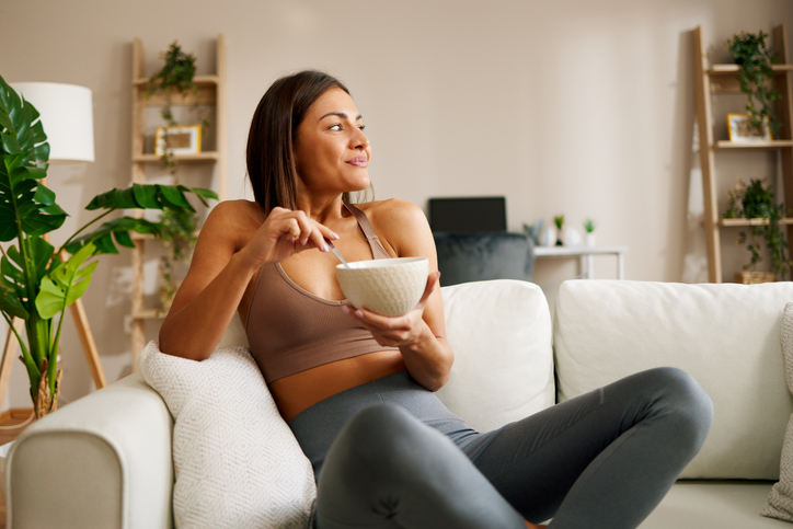 woman eating cereal on the sofa