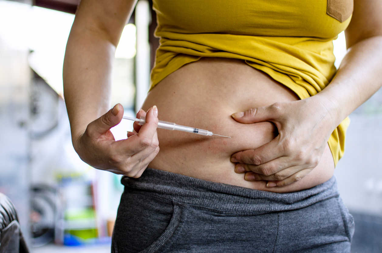 woman giving herself a weight loss injection