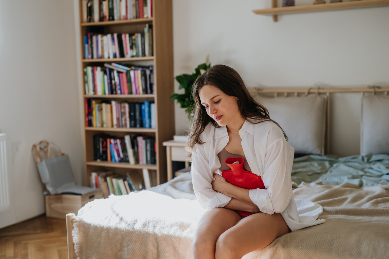 woman using a hot water bottle for adenomyosis pain
