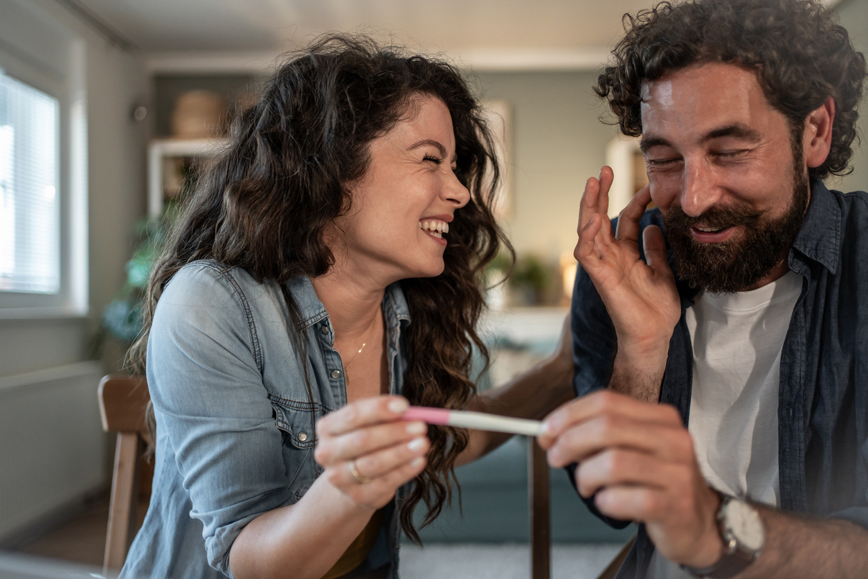 joyful couple holding a positive pregnancy test