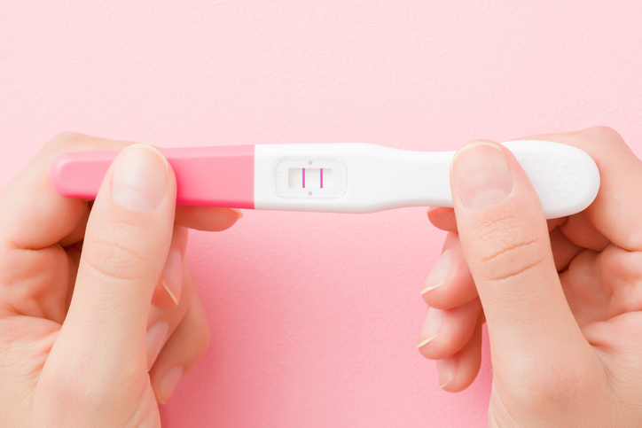 woman holding a positive pregnancy test