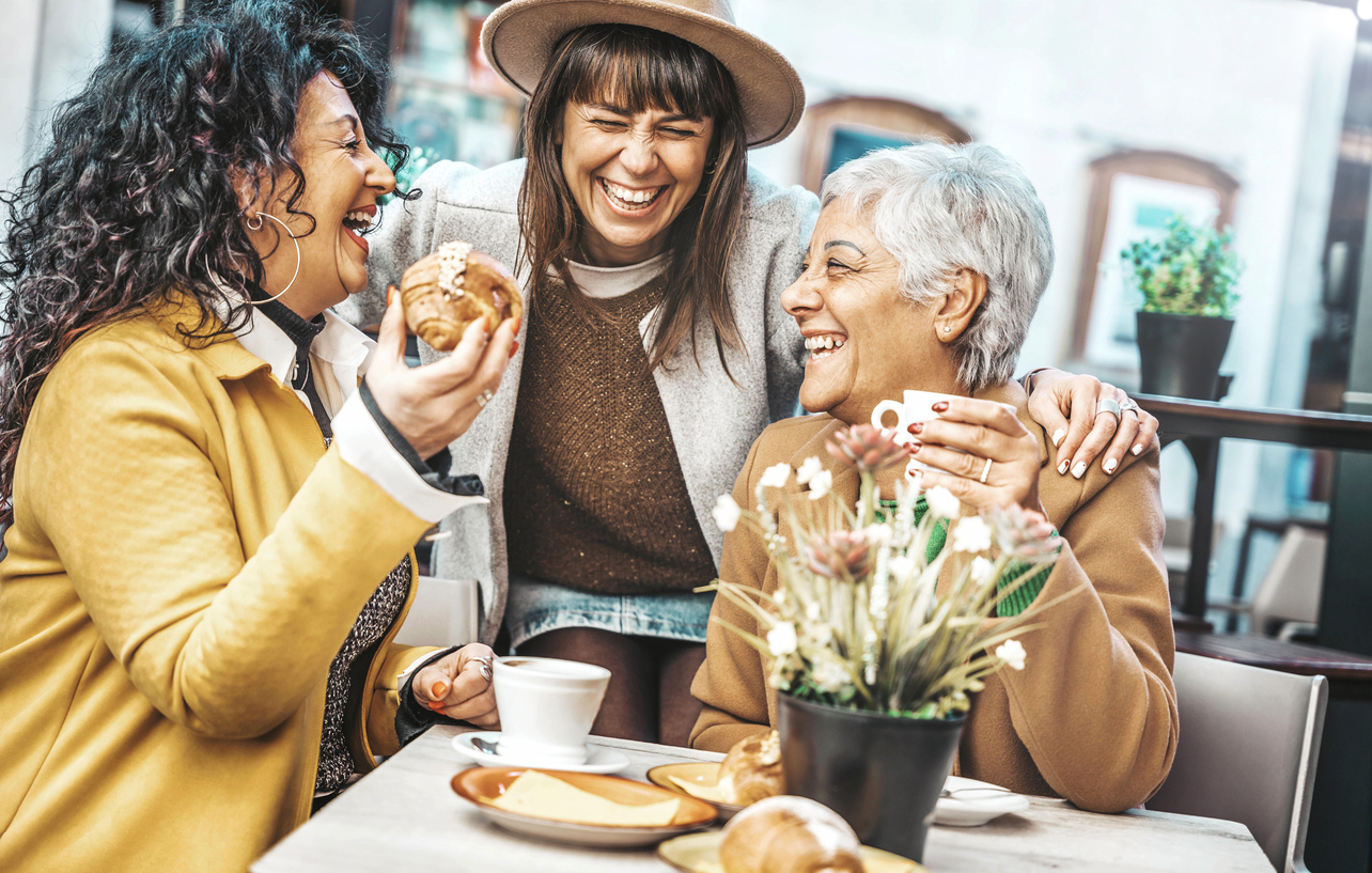 group of intergenerational women laughing and eating