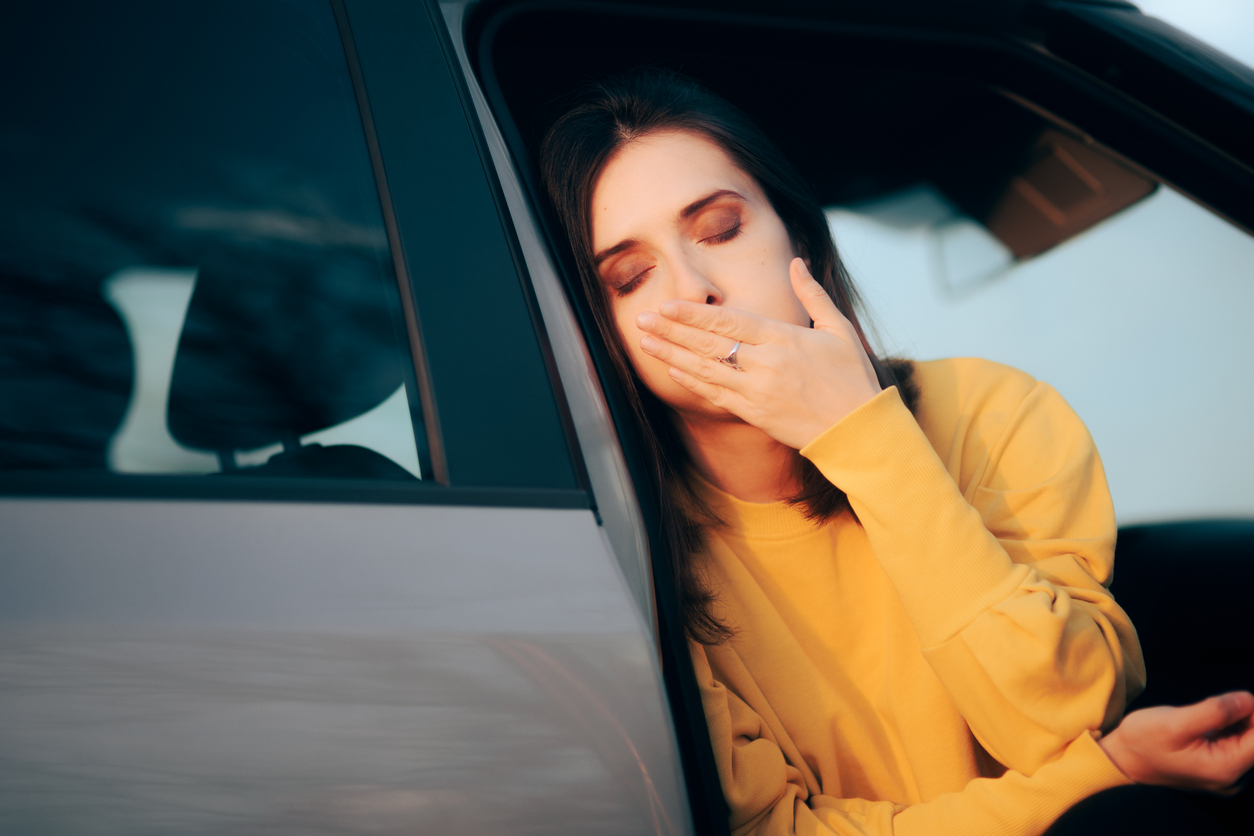 woman with motion sickness leaning out the car door 