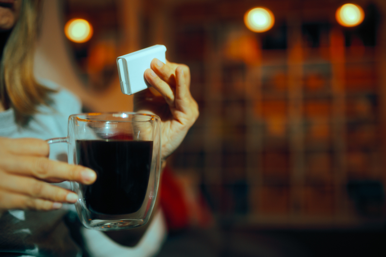 woman adding stevia to coffee