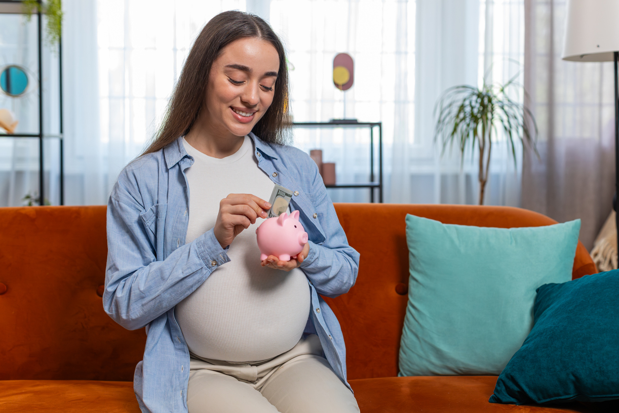 woman saving money for cord blood banking in a piggy bank 