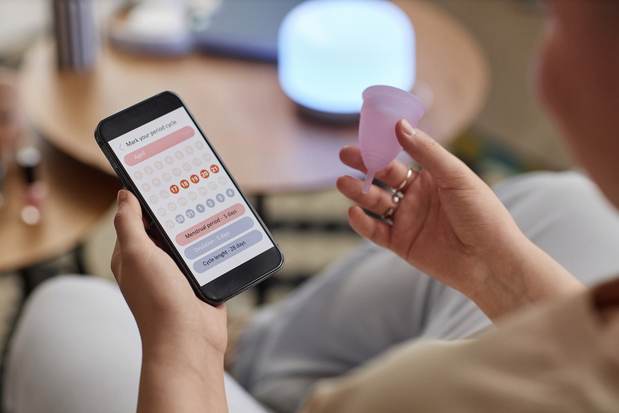 woman looking at a period tracker app on her phone