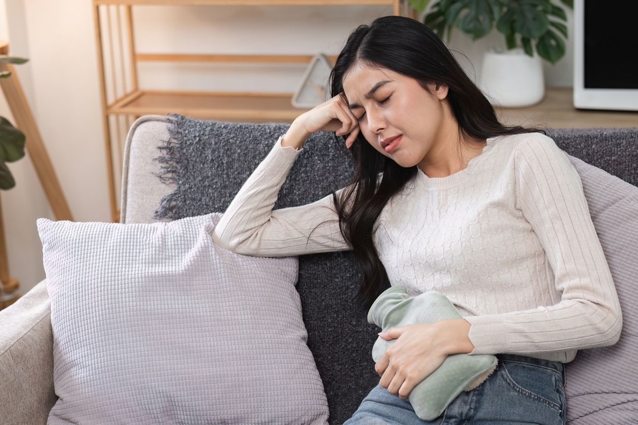 woman using a heating pad for cramps