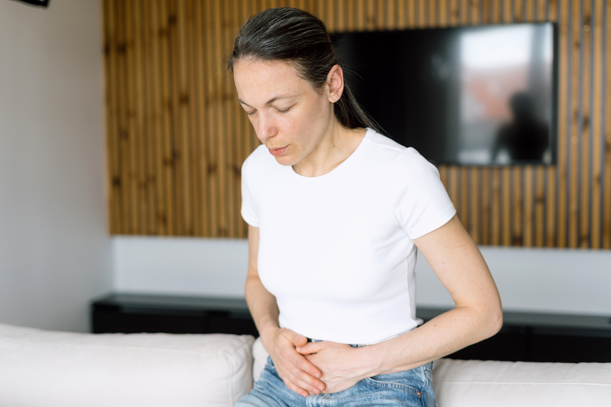 woman with cramps gripping her low belly