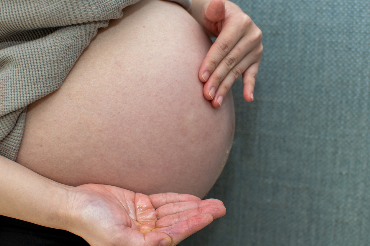 woman rubbing oil on her baby bump