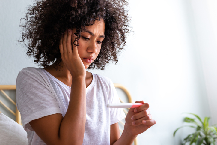woman looking at a pregnancy test