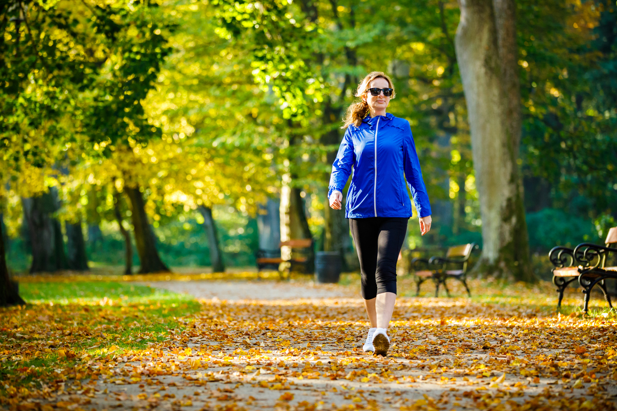 menopausal woman walking in a park