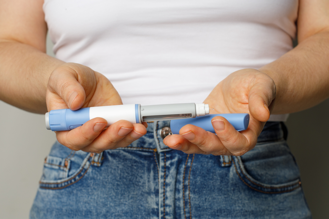 woman holding a glp-1 injectable