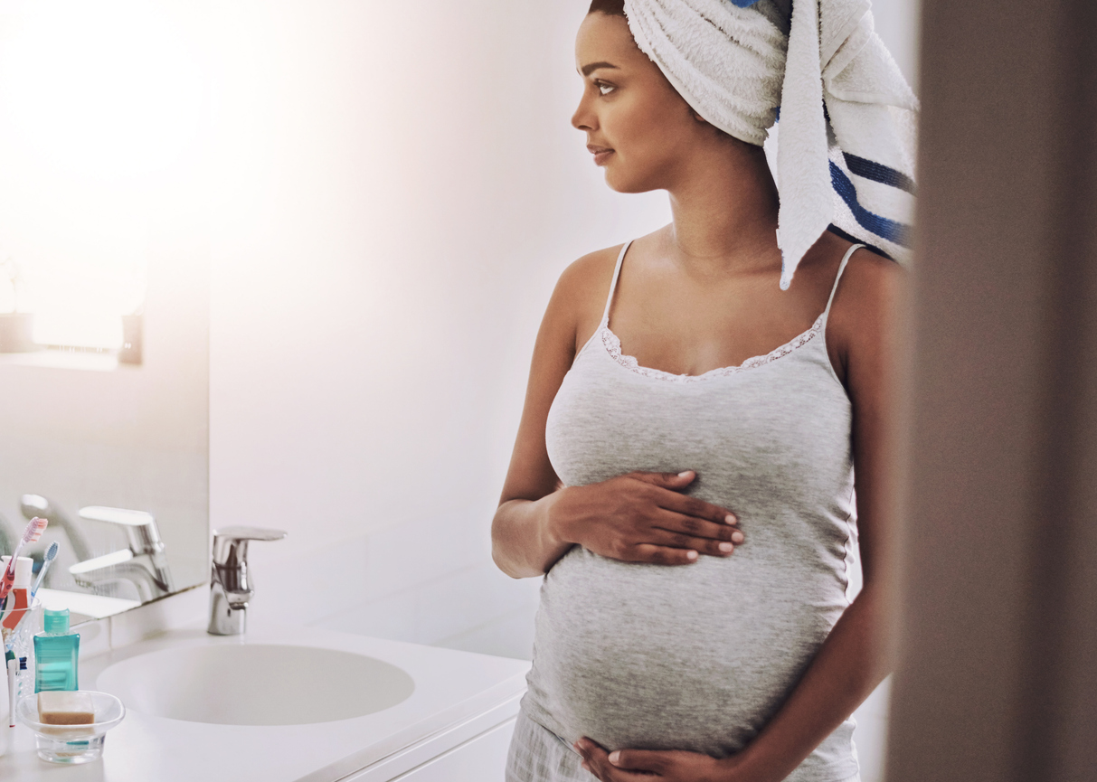 woman admiring her baby bump in the mirror