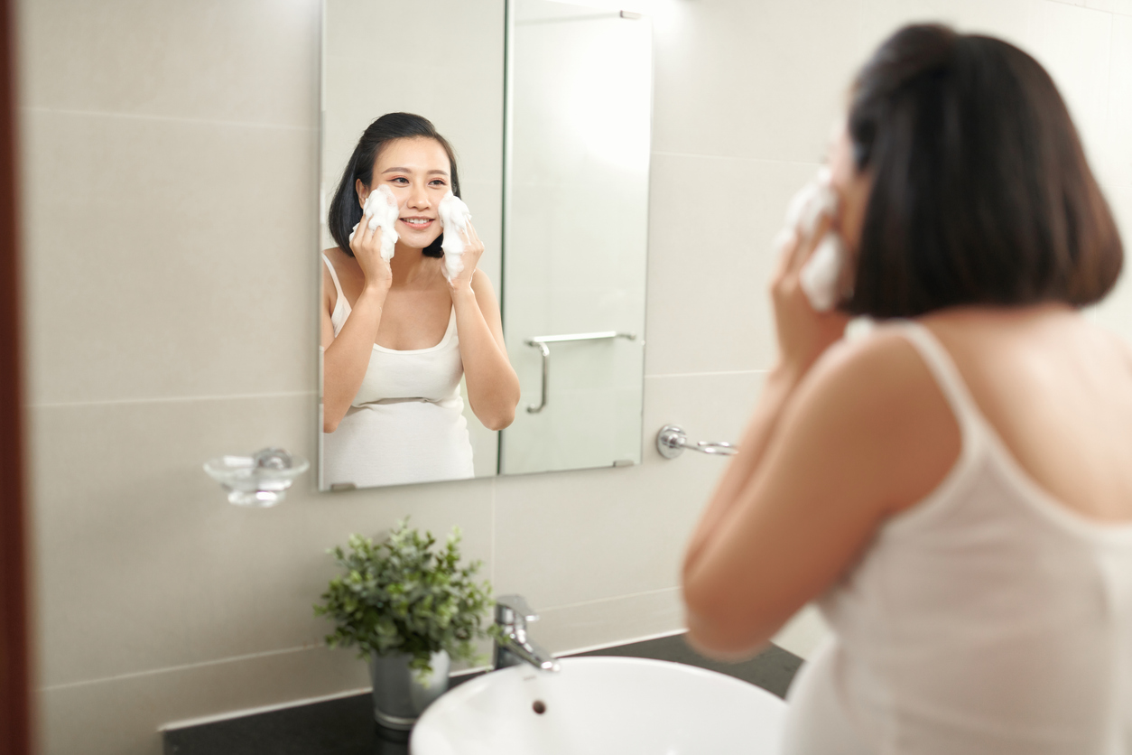 pregnant woman using a foam cleanser on her face