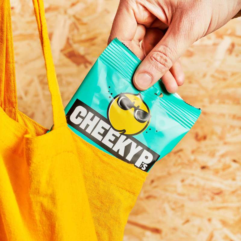 Pulling a pack of Cheeky P’s from a yellow tote bag