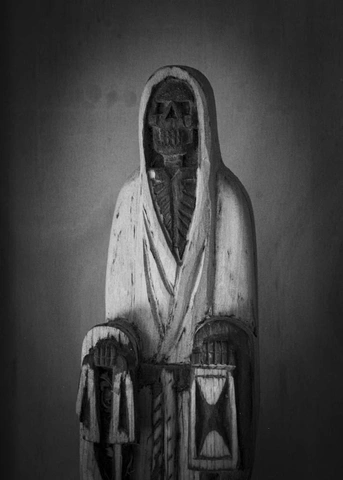 Черно-белая скульптура скелетной фигуры в капюшоне, держащей песочные часы