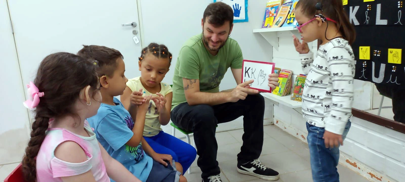 gratificação para professores. Professor assistindo crianças portadoras de necessidade especial.