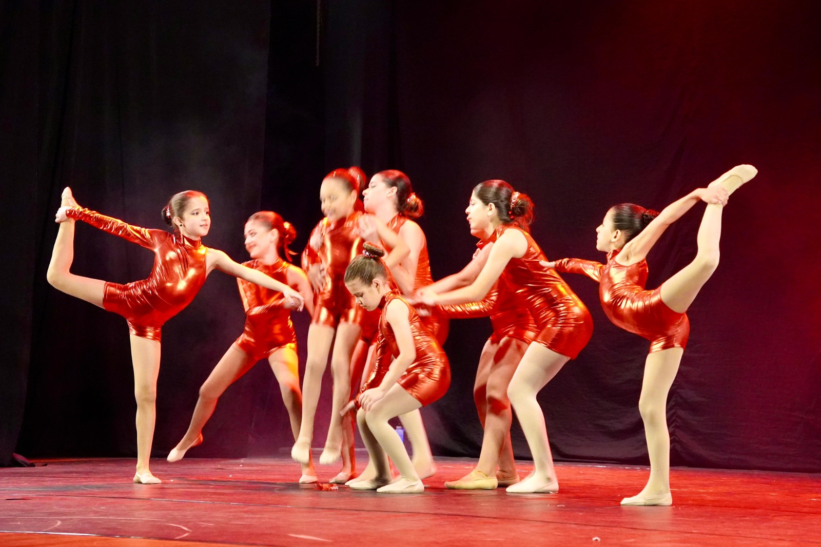 Crianças do Colégio Bliss (São José) se apresentam na 17ª Mesorregional do Festival Escolar Dança Catarina, na coreografia “Um vestido para ela”, da categoria Mirim Livre – Temática 1. As bailarinas usam figurino com orelhinhas de rato e saias lilás, dançando em frente a um manequim com vestido de gala, em destaque no palco.