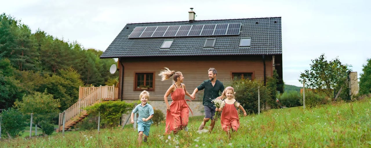 Familie im Garten vor ihrem Haus mit Photovoltaik
