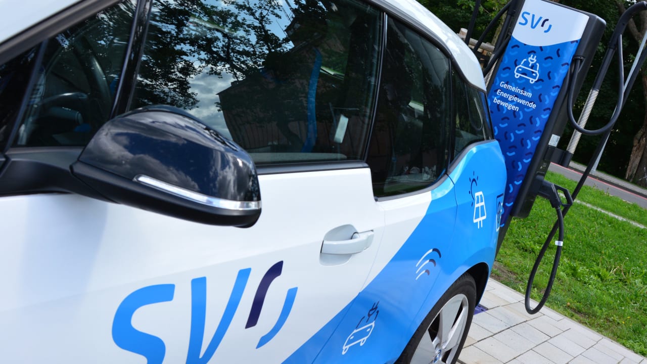Ein blauweißes E-Auto mit dem Schriftzug 