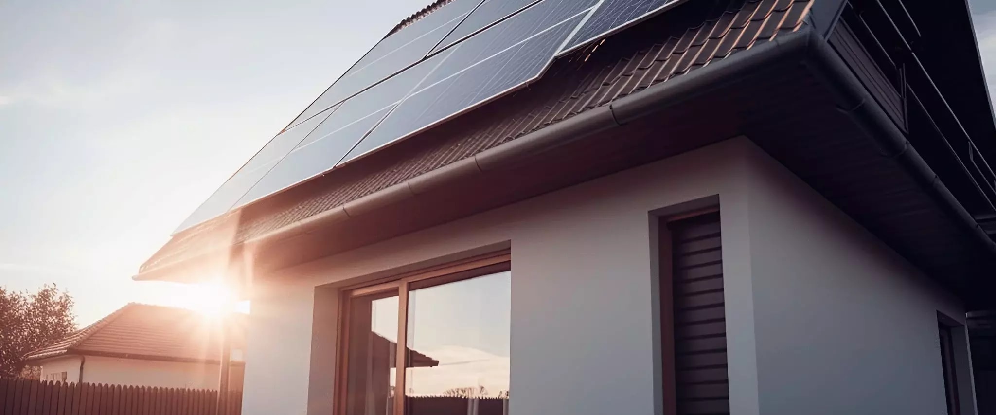 Haus mit Solaranlage auf dem Dach im Sonnenuntergang.