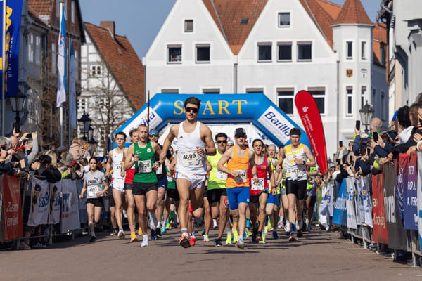 Eine Gruppe von Teilnehmenden läuft beim Celler Wasa-Lauf durch die historische Altstadt von Celle, begleitet von Zuschauern am Straßenrand.