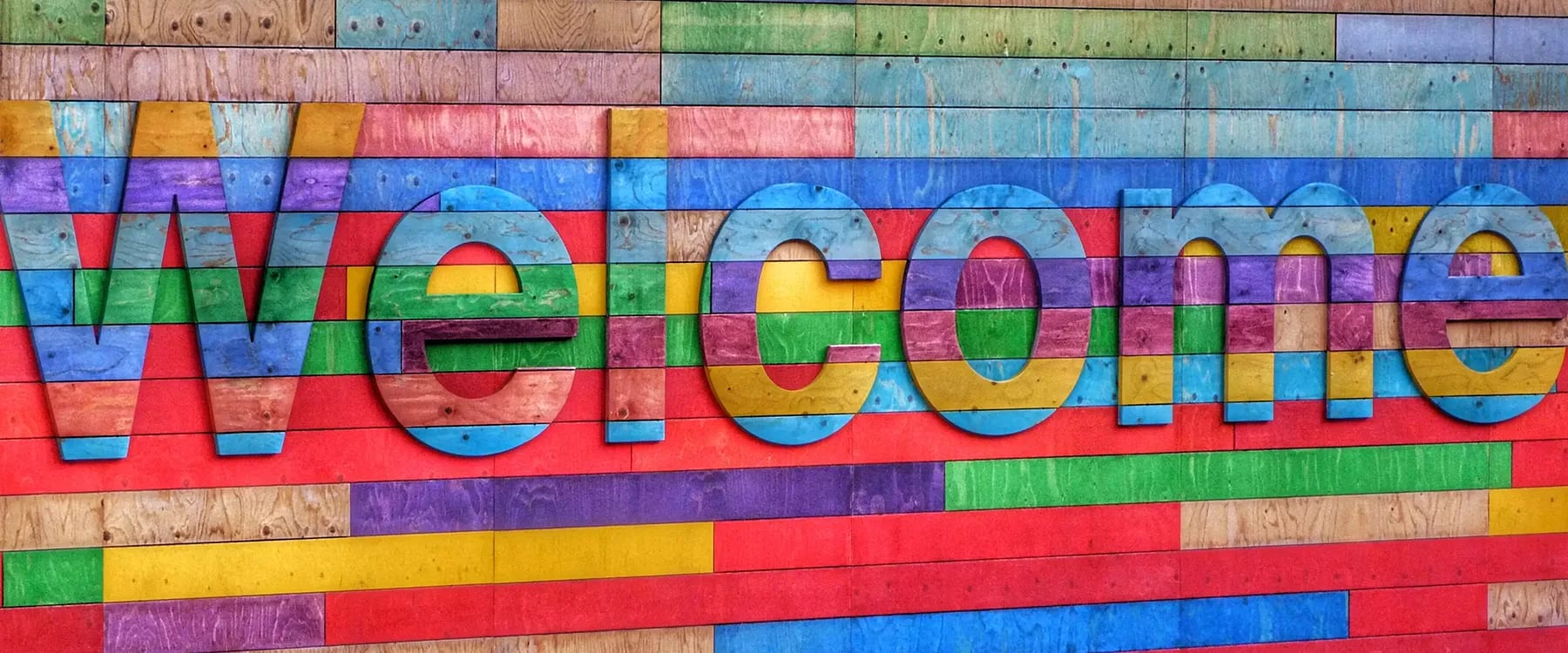Welcome-Schriftzug auf bunter Wand