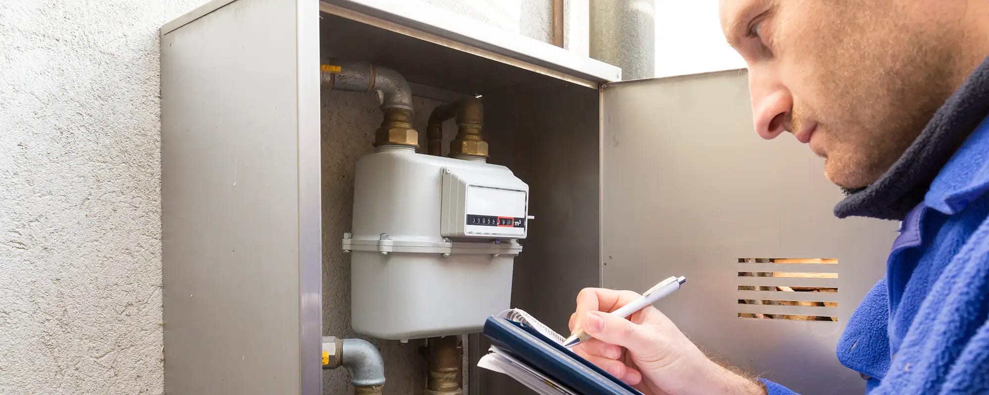 Installateur prüft Zählerstände eines Gaszählers