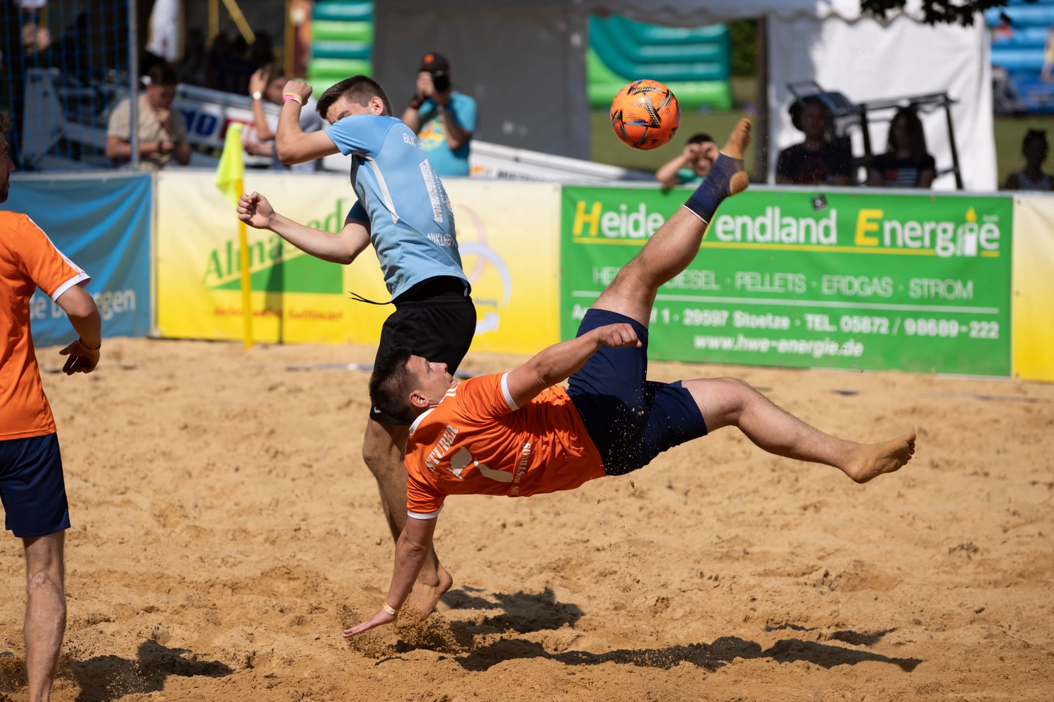 Ein Spieler schießt beim Beach Soccer Cup Natendorf mit einem Sprung in die Luft nach dem Ball.