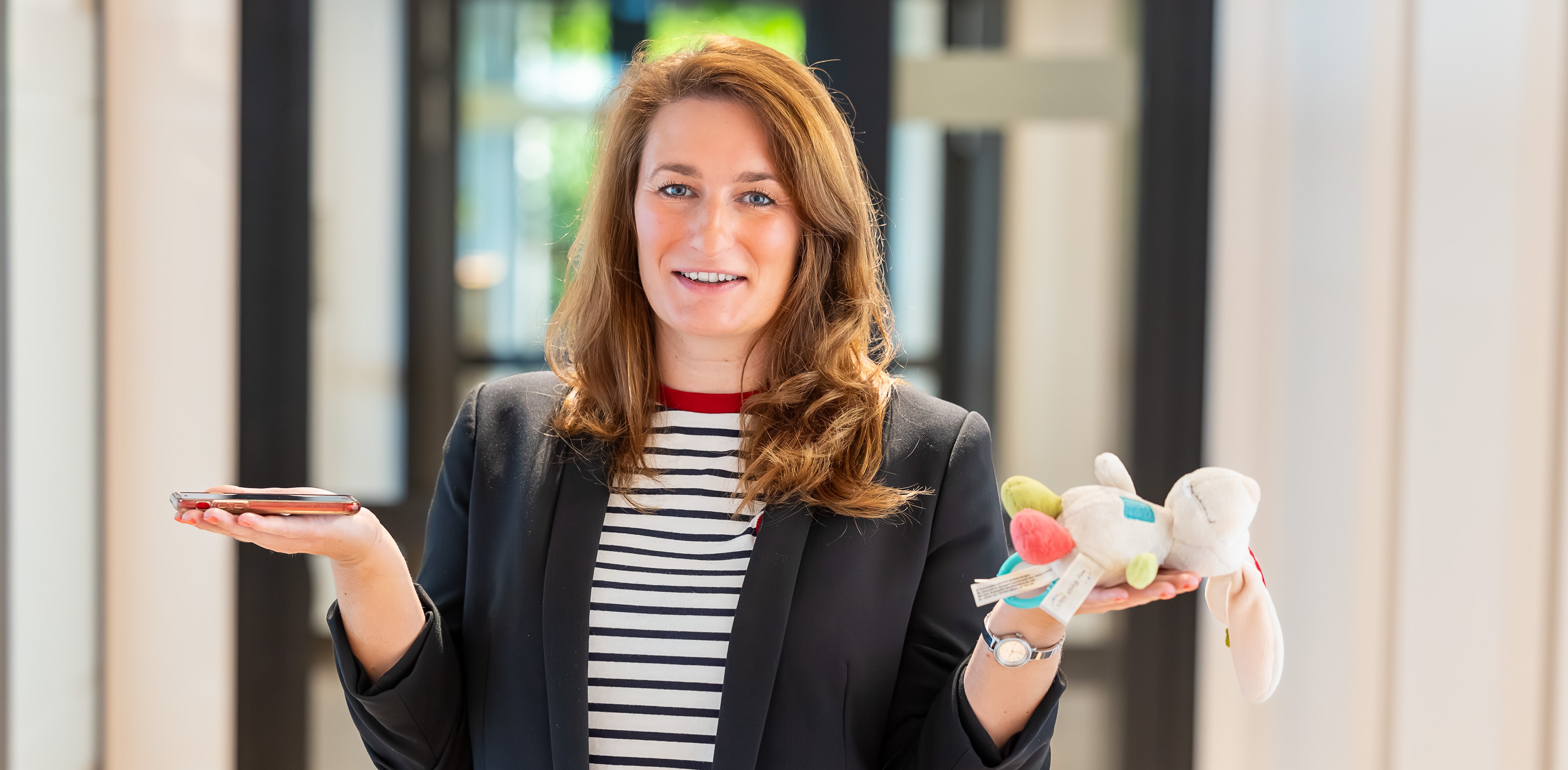Personalrefentin Christin Gabriel lächelt mit Kuscheltier in die Kamera.