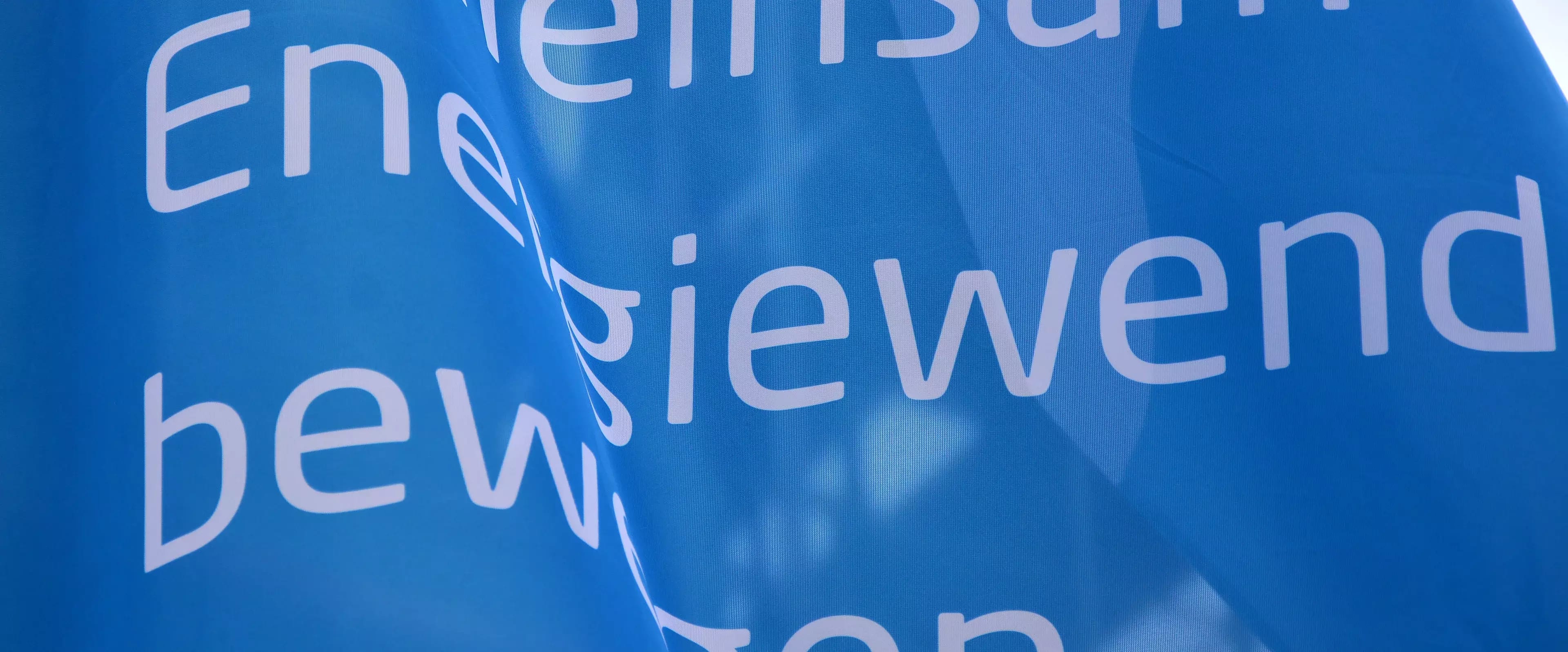 Ausschnitt einer blauen Fahne mit weißer Aufschrift 