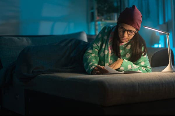 Junge Frau liest ein Buch auf dem Bett