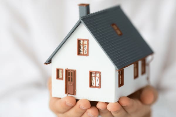 Kleines Modellhaus in Händen.