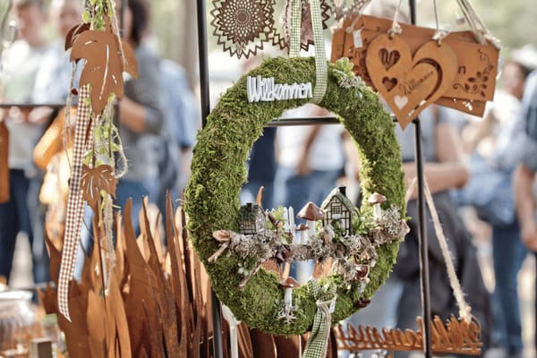 Herbstkrank hängt neben weiterer Dekoration am Stand.